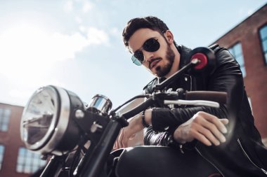 Klasik tarzı siyah motosiklet ile yakışıklı sakallı motorcu. Cafe racer.