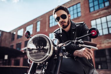 Klasik tarzı siyah motosiklet ile yakışıklı sakallı motorcu. Cafe racer.
