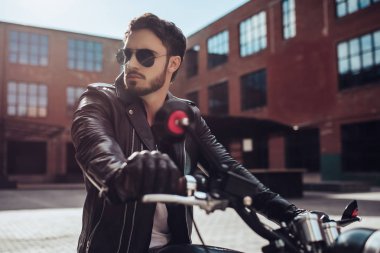 Klasik tarzı siyah motosiklet ile yakışıklı sakallı motorcu. Cafe racer.