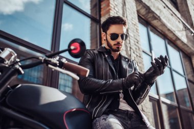 Klasik tarzı siyah motosiklet ile yakışıklı sakallı motorcu. Cafe racer.