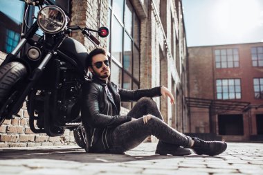 Klasik tarzı siyah motosiklet ile yakışıklı sakallı motorcu. Cafe racer.