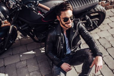 Klasik tarzı siyah motosiklet ile yakışıklı sakallı motorcu. Cafe racer.