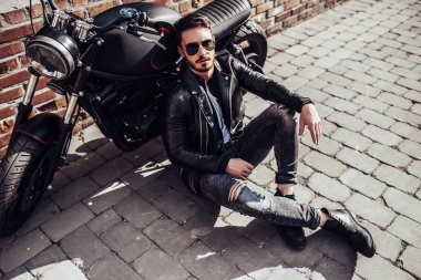 Klasik tarzı siyah motosiklet ile yakışıklı sakallı motorcu. Cafe racer.