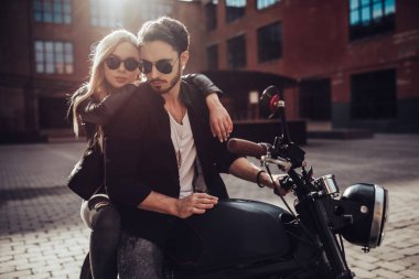 Romantik motorcu çift siyah motosiklet ile. Yakışıklı adam ve genç çekici kadın kafe racer ile açık havada sakallı.