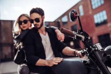 Romantik motorcu çift siyah motosiklet ile. Yakışıklı adam ve genç çekici kadın kafe racer ile açık havada sakallı.