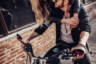 Romantik motorcu çift siyah motosiklet ile. Yakışıklı adam ve genç çekici kadın kafe racer ile açık havada sakallı.