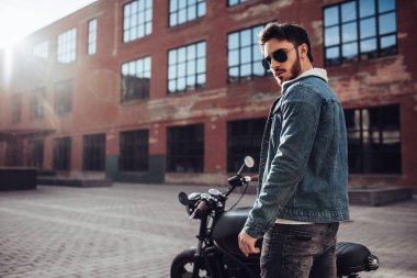 Klasik tarzı siyah motosiklet ile yakışıklı sakallı motorcu. Cafe racer.