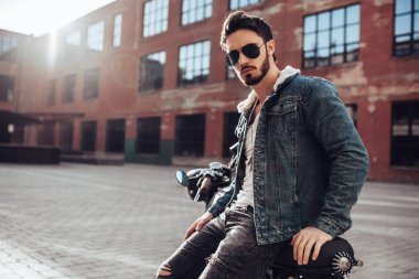 Klasik tarzı siyah motosiklet ile yakışıklı sakallı motorcu. Cafe racer.