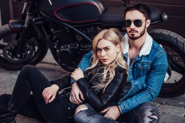 Romantik motorcu çift siyah motosiklet ile. Yakışıklı adam ve genç çekici kadın kafe racer ile açık havada sakallı.