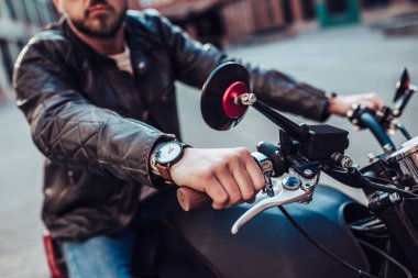 Klasik tarzı siyah motosiklet ile yakışıklı sakallı motorcu görüntü kırpılmış. Cafe racer.