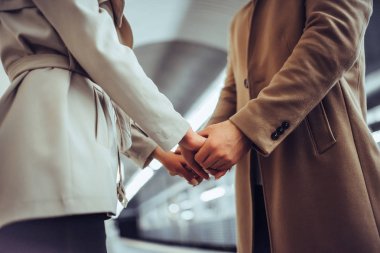 Genç romantik çift Metro kırpılmış. Yeraltı aşk hikayesi. El ele tutuşarak çiftin yakın çekim.