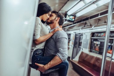 Young romantic couple in subway. Underground love story. clipart