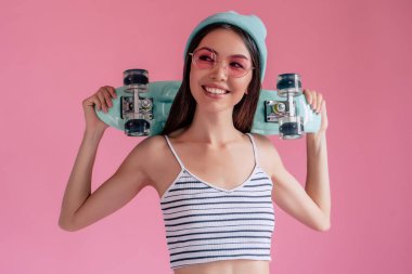 Pembe pembe gözlüklü Genç Asyalı Genç kızı. Patenci kız şort izole kaykay ile.