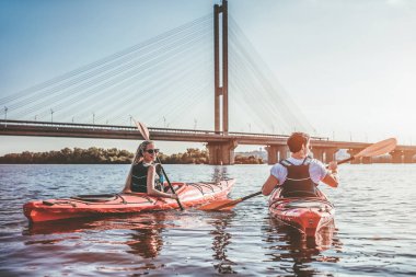 Güzel genç çift nehir kanosu. Gün batımı bekliyor. Birlikte Kano