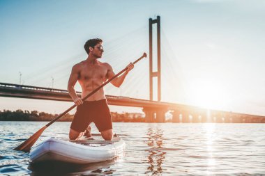Raket Pano ayağa adam. Günbatımı sırasında Sup tahta üzerinde eğleniyor. Aktif yaşam tarzı.