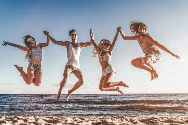 Grupa Młodych Przyjaciół Atrakcyjne Zabawy Plaży Skoki Uśmiechając Się — Zdjęcie stockowe