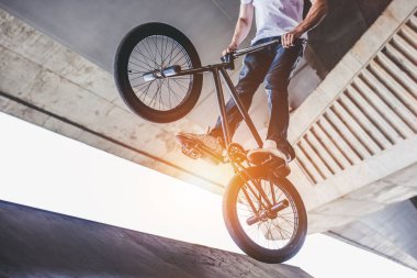 Genç Bmx sürücüsü kırpılmış görüntü hileler skatepark içinde gerçekleştiriyor.