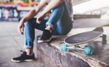 Genç adam kaykaycı kırpılmış görüntü. Erkek genç skatepark longboard ile.