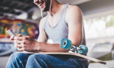 Genç adam kaykaycı kırpılmış görüntü. Erkek genç skatepark longboard ile.