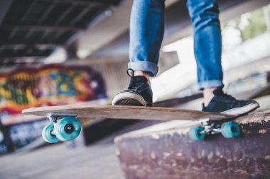 Genç adam kaykaycı kırpılmış görüntü. Erkek genç skatepark longboard ile.