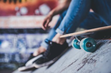 Genç adam kaykaycı kırpılmış görüntü. Erkek genç skatepark longboard ile.