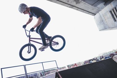 Genç Bmx sürücüsü hileler skatepark içinde gerçekleştiriyor.