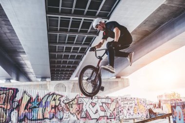 Genç Bmx sürücüsü hileler skatepark içinde gerçekleştiriyor.
