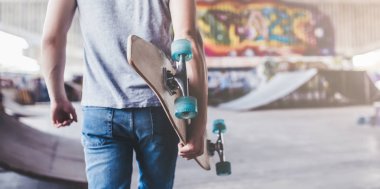 Genç adam kaykaycı kırpılmış görüntü. Erkek genç skatepark longboard ile.