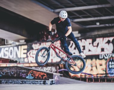 Genç Bmx sürücüsü hileler skatepark içinde gerçekleştiriyor.