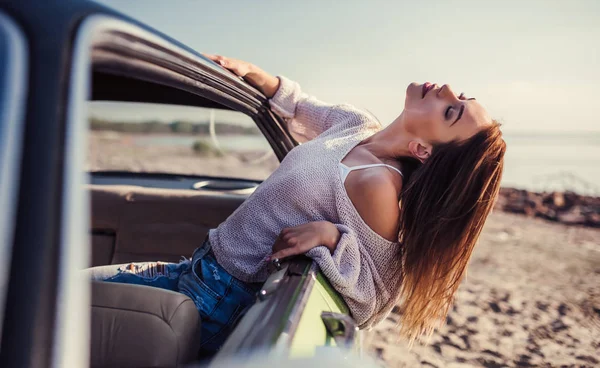 Macera ruhu hissediyorum! Çekici genç kadın yeşil retro araba penceresinden yaslanmış. Vintage Klasik Otomobil.