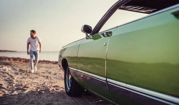 Красивый Бородатый Мужчина Идет Своей Зеленой Ретро Машине Стоящей Пляже — стоковое фото