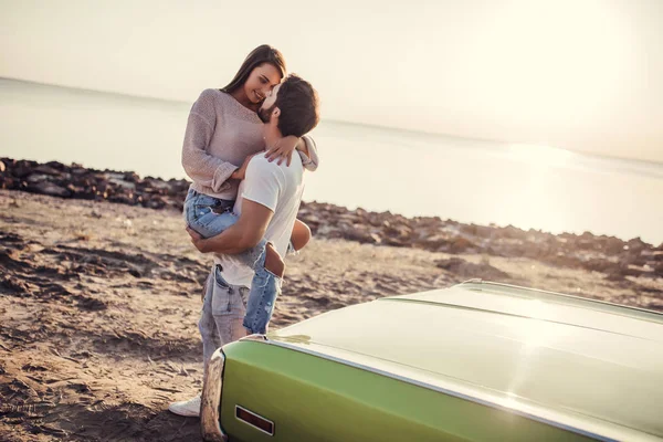 浪漫情侣站在海滩上的绿色复古汽车附近 英俊的胡子男子和迷人的年轻女子老式的经典轿车 爱情故事 — 图库照片