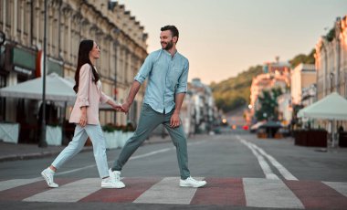 Havada aşk var! Güzel romantik çift birlikte şehirde bir yaya geçidi üzerinde yürürken vakit. Sakallı yakışıklı ve çekici genç kadın aşığız.