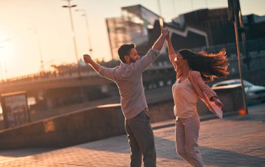 Havada aşk var! Güzel romantik çift şehirde birlikte vakit. Sakallı yakışıklı ve çekici genç kadın aşığız. Günbatımı sırasında dans.