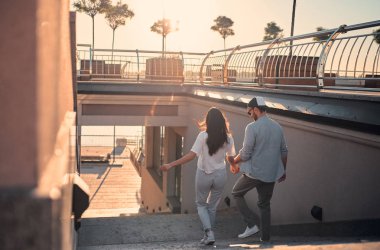 Havada aşk var! Güzel romantik çift vakit birlikte günbatımı sırasında şehirde. Sakallı yakışıklı ve çekici genç kadın aşığız.