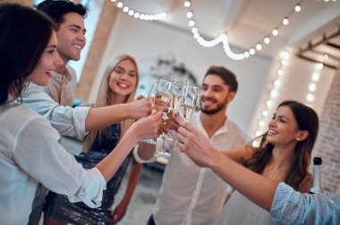 Hadi parti başlasın! Bir grup genç insan birlikte eğleniyor. Şampanya ile büyük ışık odasında dans. Büyük şirket yakın arkadaşım tatil kutluyor.