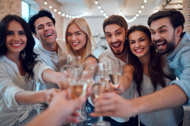 Hadi parti başlasın! Bir grup genç insan birlikte eğleniyor. Şampanya ile büyük ışık odasında dans. Büyük şirket yakın arkadaşım tatil kutluyor.