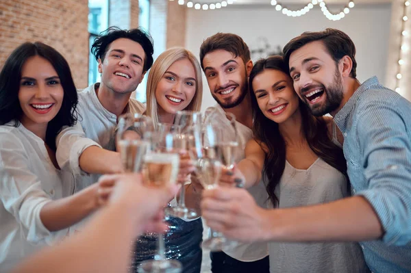 パーティーを始めましょう 一緒に楽しんで若い人たちのグループです シャンパンと大きな明るい部屋で踊る 親しい友人の大きな会社の祝日を祝う — ストック写真