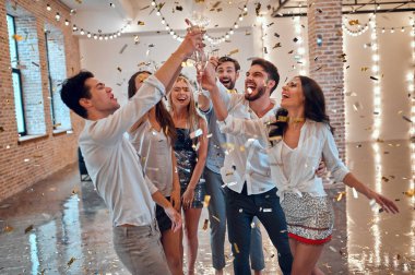 Hadi parti başlasın! Bir grup genç insan birlikte eğleniyor. Şampanya ve konfeti düşen ışık oda dans. Büyük şirket yakın arkadaşım tatil kutluyor.