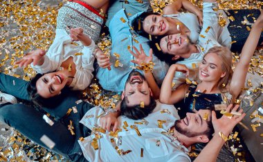 Hadi parti başlasın! Bir grup genç insan birlikte eğleniyor. Yere düşen konfeti ile yalan. Büyük şirket yakın arkadaşım tatil kutluyor.