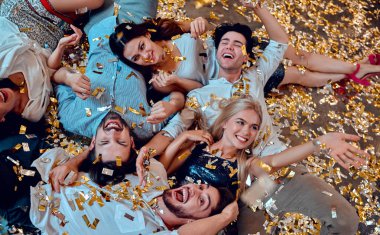 Hadi parti başlasın! Bir grup genç insan birlikte eğleniyor. Yere düşen konfeti ile yalan. Büyük şirket yakın arkadaşım tatil kutluyor.