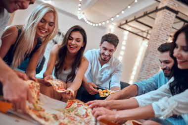 Hadi parti başlasın! Bir grup genç insan birlikte eğleniyor. Büyük ışık odada şampanya ve pizza ile oturuyor. Büyük şirket yakın arkadaşım tatil kutluyor.