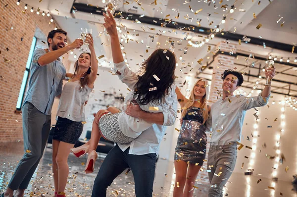 让派对开始吧 一群年轻人在一起玩得很开心 在大光室里跳舞 里面有香槟和五彩纸屑 在亲密朋友的大公司庆祝节日 — 图库照片