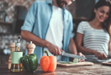 Romantik Çift mutfak yemek pişiriyor. Yakışıklı ve çekici genç kadın birlikte salata yaparken eğleniyor musun. Sağlıklı yaşam konsepti.