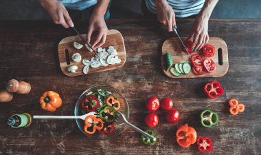 Romantik Çift kırpılmış görüntü üzerinde mutfak yemek pişiriyor. Yakışıklı ve çekici genç kadın birlikte salata yaparken eğleniyor musun. Sağlıklı yaşam konsepti.