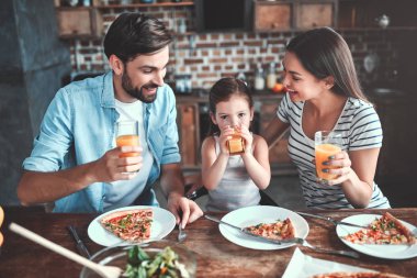 Anne, baba ve kızı mutfak birlikte yemek yiyor. Mutlu aile kavramı.