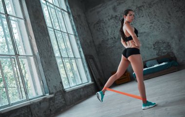 Genç sportif kadın evde egzersizleri yapıyor. Mükemmel vücut şekli ile seksi kadın