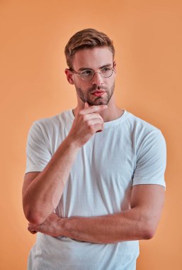 Yakışıklı adam izole. Gözlük şık genç adam turuncu arka plan üzerinde poz.