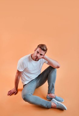 Yakışıklı adam izole. Turuncu arka plan üzerinde poz şık genç adam.