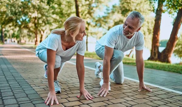 年配のカップルは屋外のスポーツをやっています 朝の公園でランニング — ストック写真